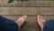 Bare feet of a relaxed person sitting on a wooden porch in a village, rural view