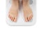 Bare feet on weight scale isolated, overweight control, obese problem, lost weight concept