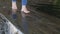 Bare feet of a young girl walking on the water in an artificial pool in the city park