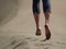 Bare feet of young woman jogging/walking on the beach at sunrise