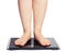 Bare female feet standing on bathroom scale