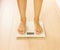 Bare female feet standing on the scales. Healthy lifestyle, food and sport concept