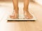 Bare female feet standing on the scales. Healthy lifestyle, food and sport concept