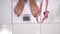 Bare female feet stepping onto a bathroom scale