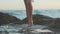 Bare female feet walking on rocky beach. Legs passing the stone on se shore.