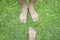Bare foot of Asian woman and man standing over green grass for relaxing