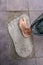 Bare foot girl stands on the stone footprint