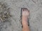 Bare foot of a man on natural soft sandy soil ground