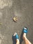 Bare male legs in blue slippers on the asphalt ground