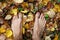 Bare man feet stands on colored autumn foliage, top view