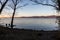 Bare, naked trees silhouettes at sunset on Trasimeno lake shore Umbria, Italy