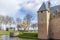 Bare trees, moat, green grass, Radboud castle tower with brick walls and canons in the background