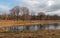 Bare trees reflected in the water surface of a small lake