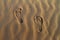 Barefeet footprints on the sand dune