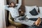 Barefoot african american man with closed eyes relaxing in armchair with laptop