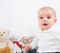 Barefoot baby on white background with cuddly toys - cute little