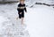 Barefoot boy of 4-5 years old runs joyfully in the snow