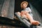 Barefoot boy sits on ladder in barn attic