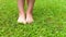 barefoot child girl walking on a green grass outdoor after the rain