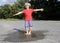 barefoot child joyfully jumps in a transparent puddle on the pavement after the rain