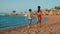 Barefoot children having fun at seashore in sunset. Sibling running on sea beach