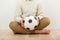 Barefoot cross-legged boy holding a soccer ball