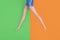 Barefoot doll legs on green and orange background