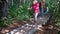 Barefoot family mother with son and daughter walking on tree trunk logs pathway