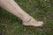 Barefoot with fashionable boho anklet on the grass background