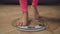 Barefoot female legs standing on weighing scale