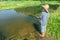 Barefoot fishing boy angling in transparent