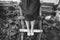 Barefoot girl in old rustic clothes is sitting on the ladder near wooden house. Summer day on farm barnyard. Stylish vintage