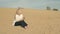 Barefoot girl sitting on the sand with the phone