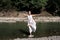 Barefoot girl standing in the water and doing yoga exercises,