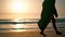 Barefoot girl walking beach sand at summer sunrise. Woman stepping seashore.