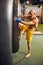 Barefoot kickboxer practicing knee strikes at the gym