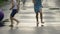 Barefoot kids running through puddles after rain, summer camp, entertainment