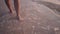 Barefoot lady legs walk along waves on shore slow motion