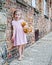 Barefoot Little Girl next to Brick Wall