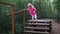 Barefoot little girl walk through wooden logs bridge. Foot massage path