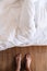 Barefoot male standing in front of the bed