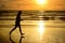 Barefoot man running ocean beach sunset.