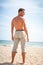 Barefoot man stands on sandy summer beach