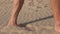 Barefoot man walking on desert sand closeup. Male shadow and footprint on sand