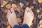 Barefoot person standing on the ground in autumn forest