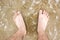 Barefoot in sea with foam