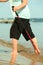 Barefoot senior nordic walking on a beach.