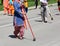 Barefoot Sikh woman cleans the street during a religious celebra