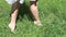 Barefoot slender legs of woman walking in tall grass