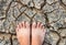 Barefoot standing on dry and cracked ground background